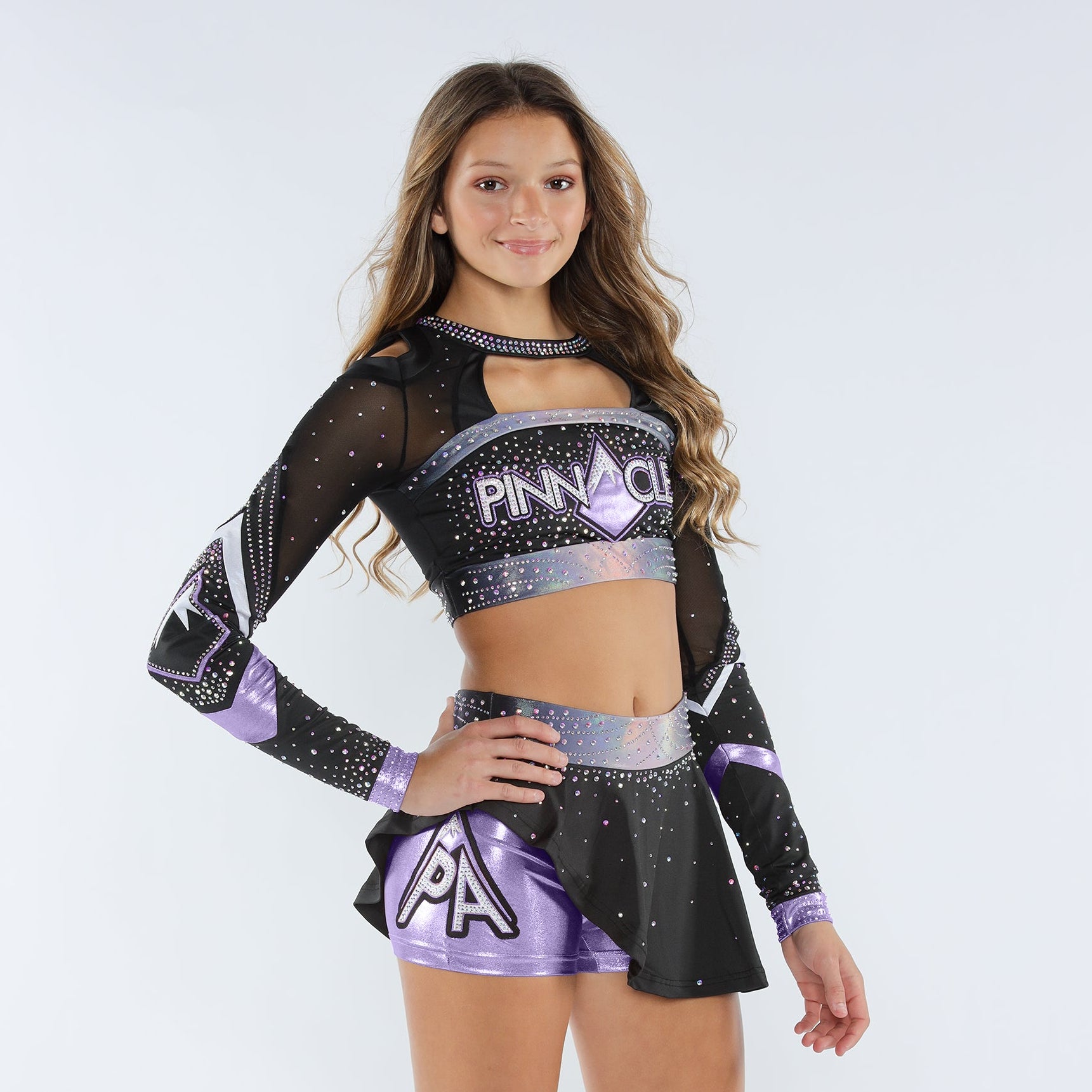 A female model wearing a lavender and black cheerleading uniform with 'PINNACLE' written on the chest and a flouncy skirt.